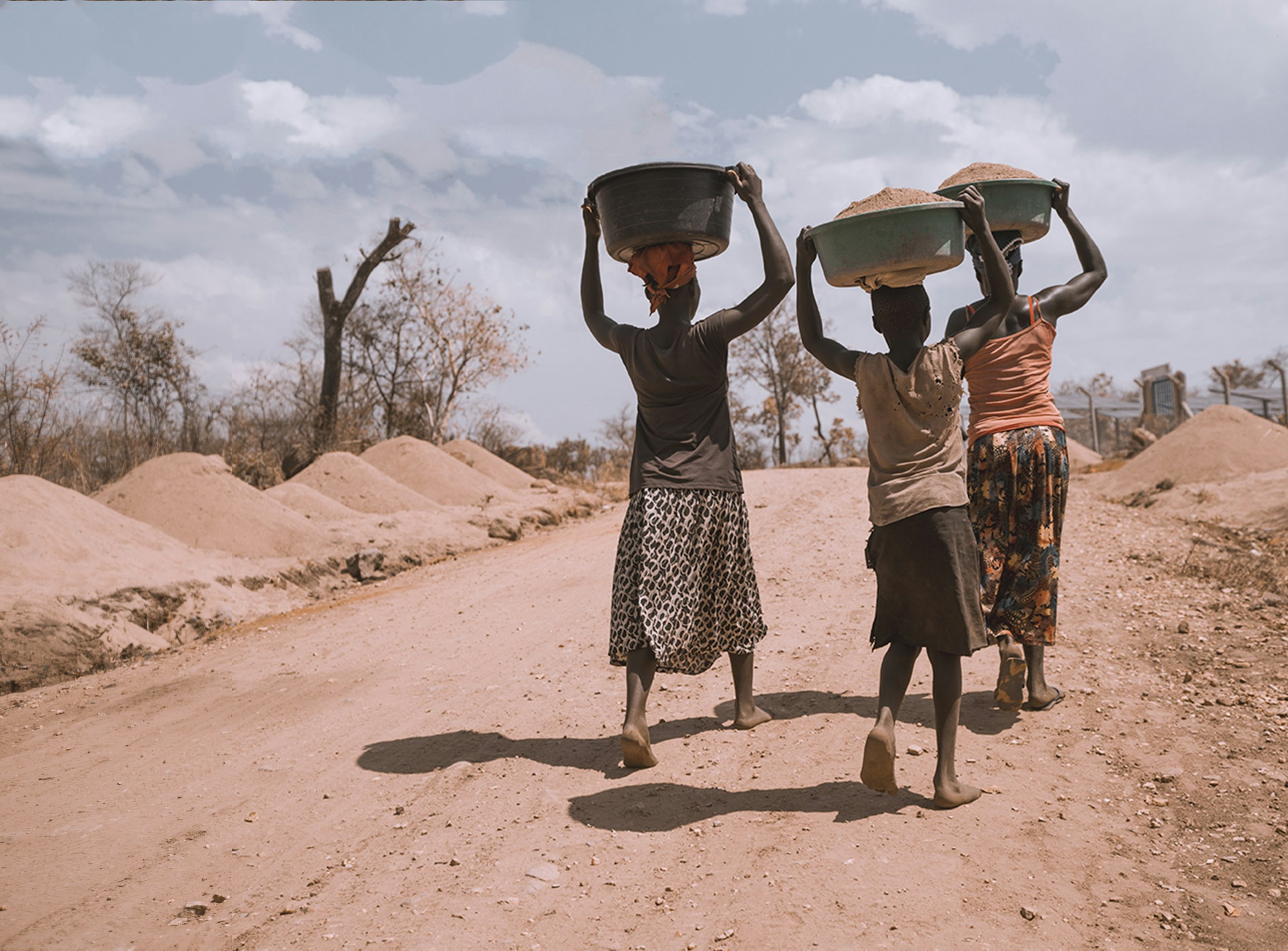 Women carrying basins barefoot at Rhino Refugee Camp, Arua, Uganda