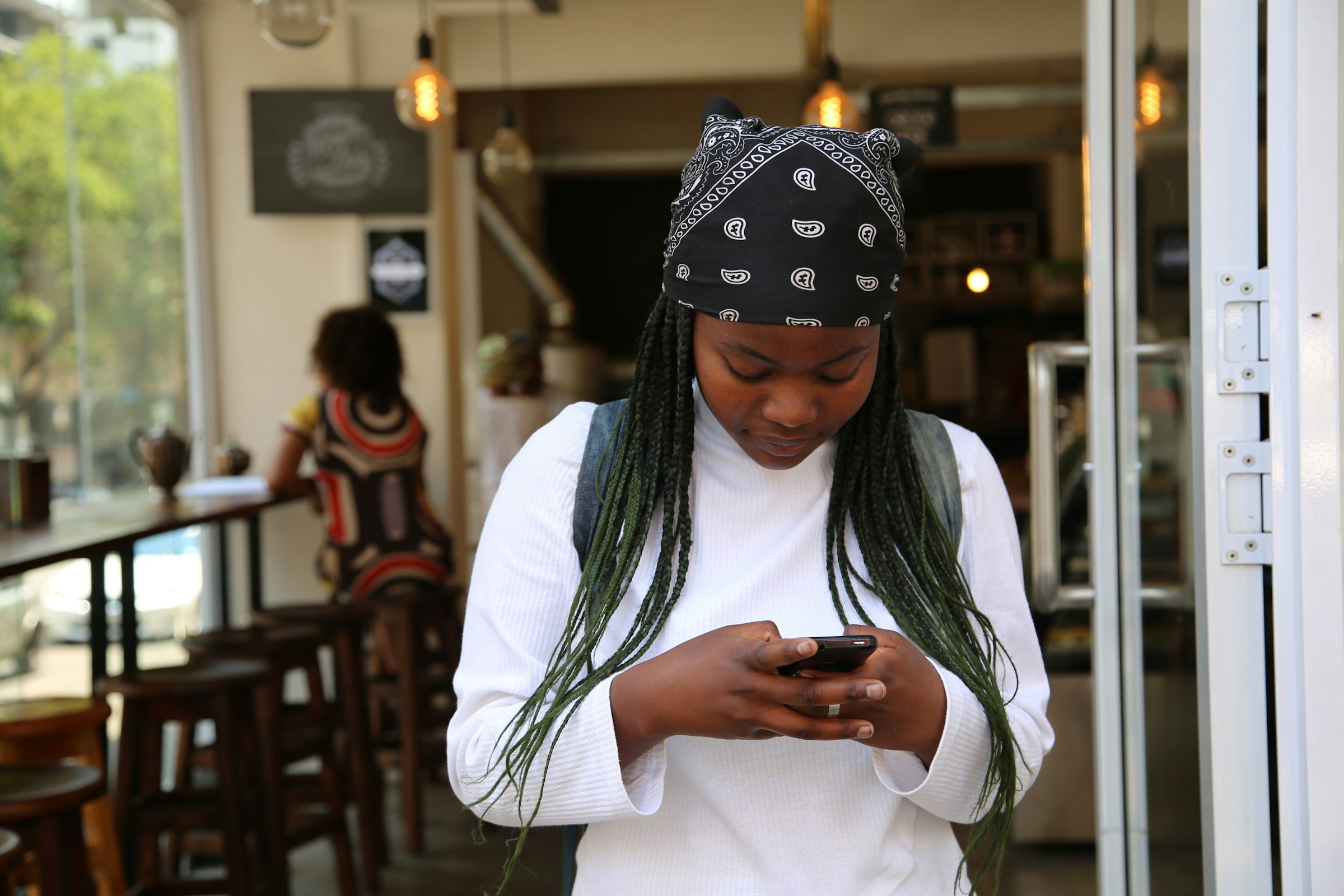 Young woman using her smartphone at a cafe in Johannesburg, South Africa