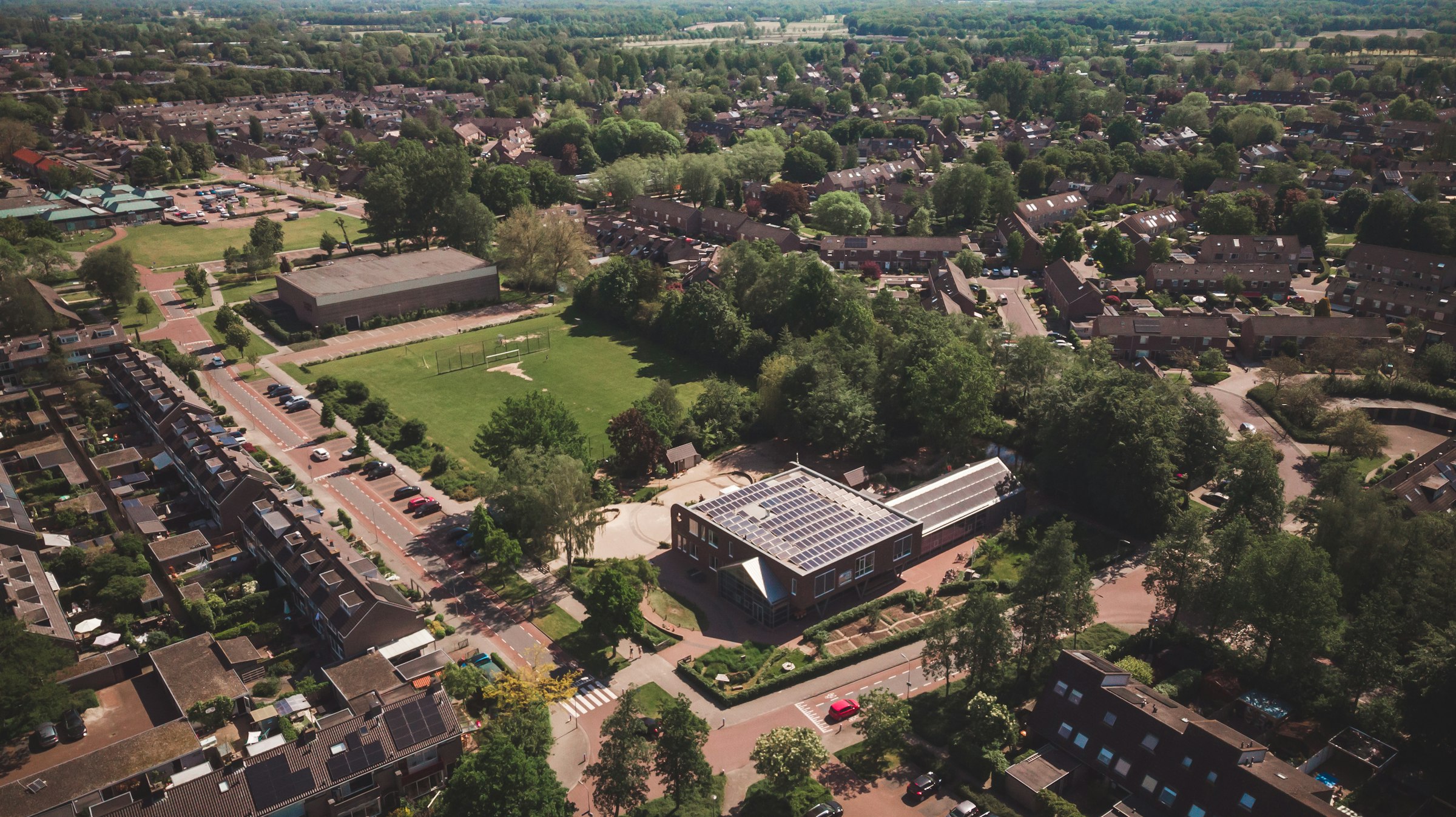 Aerial drone view of a primary school building with solar roof panels