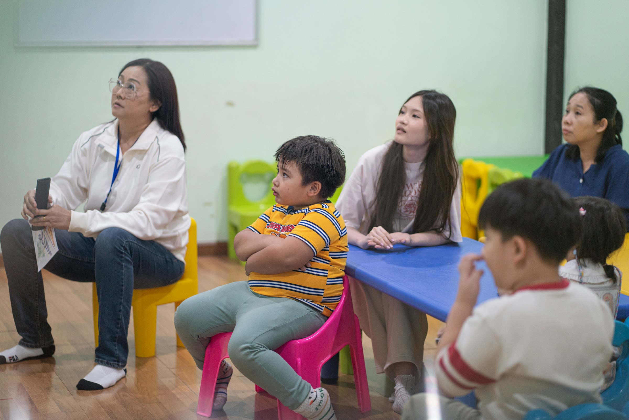Adults and children gathered together in a classroom setting
