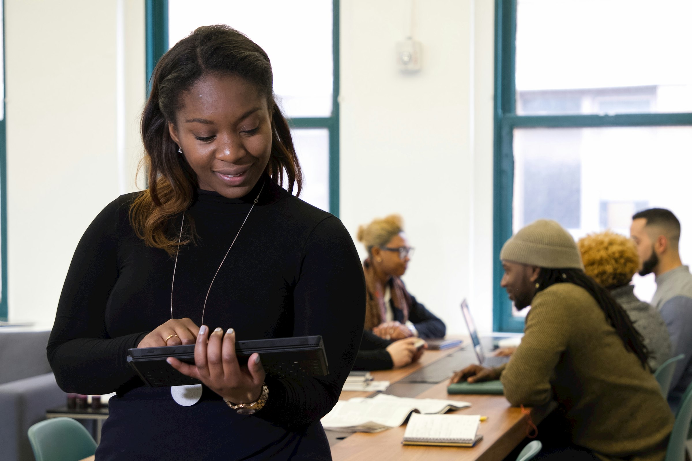 Businesswoman standing at a table holding a tablet