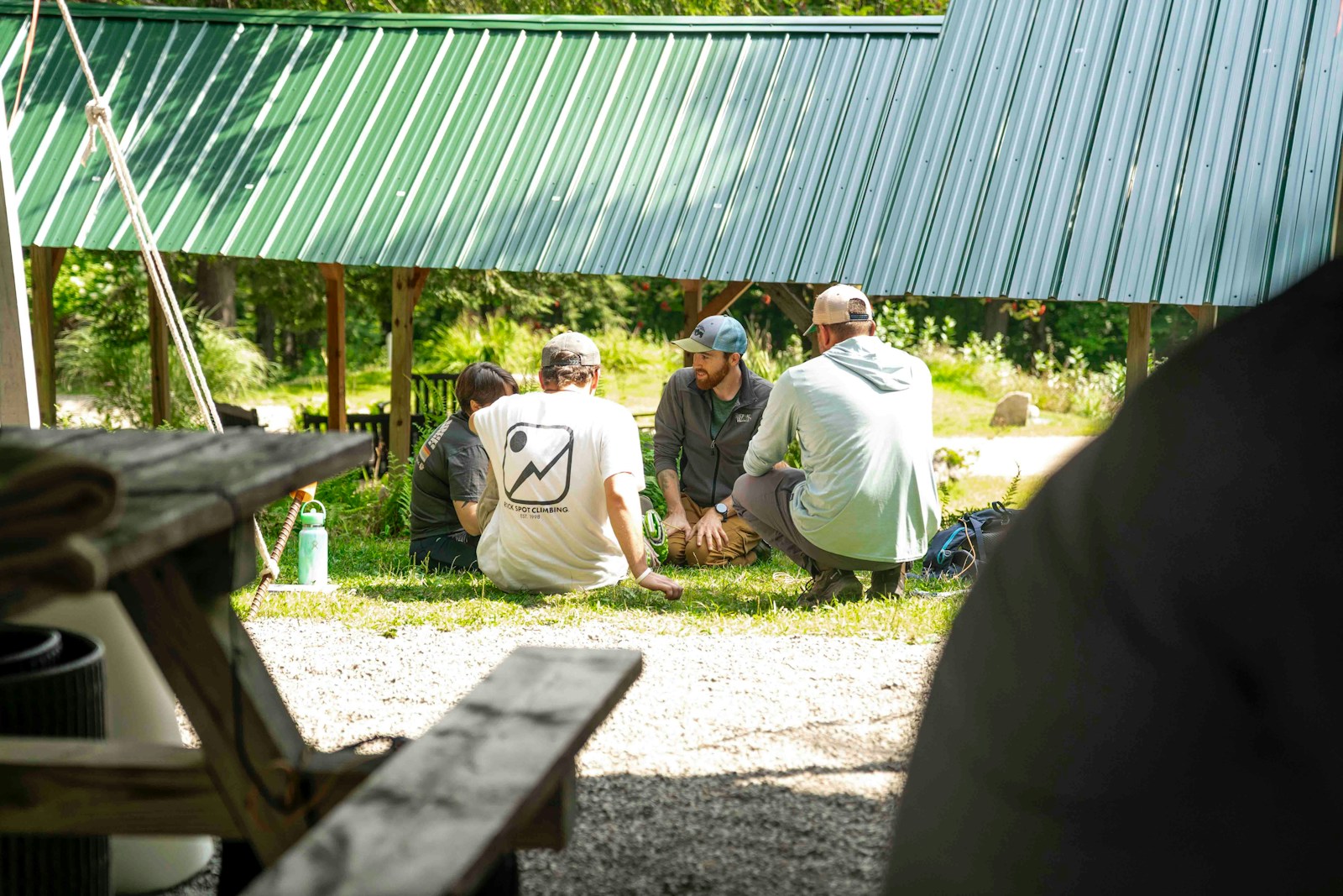 A group of people gathered in a circle outdoors for a community meeting