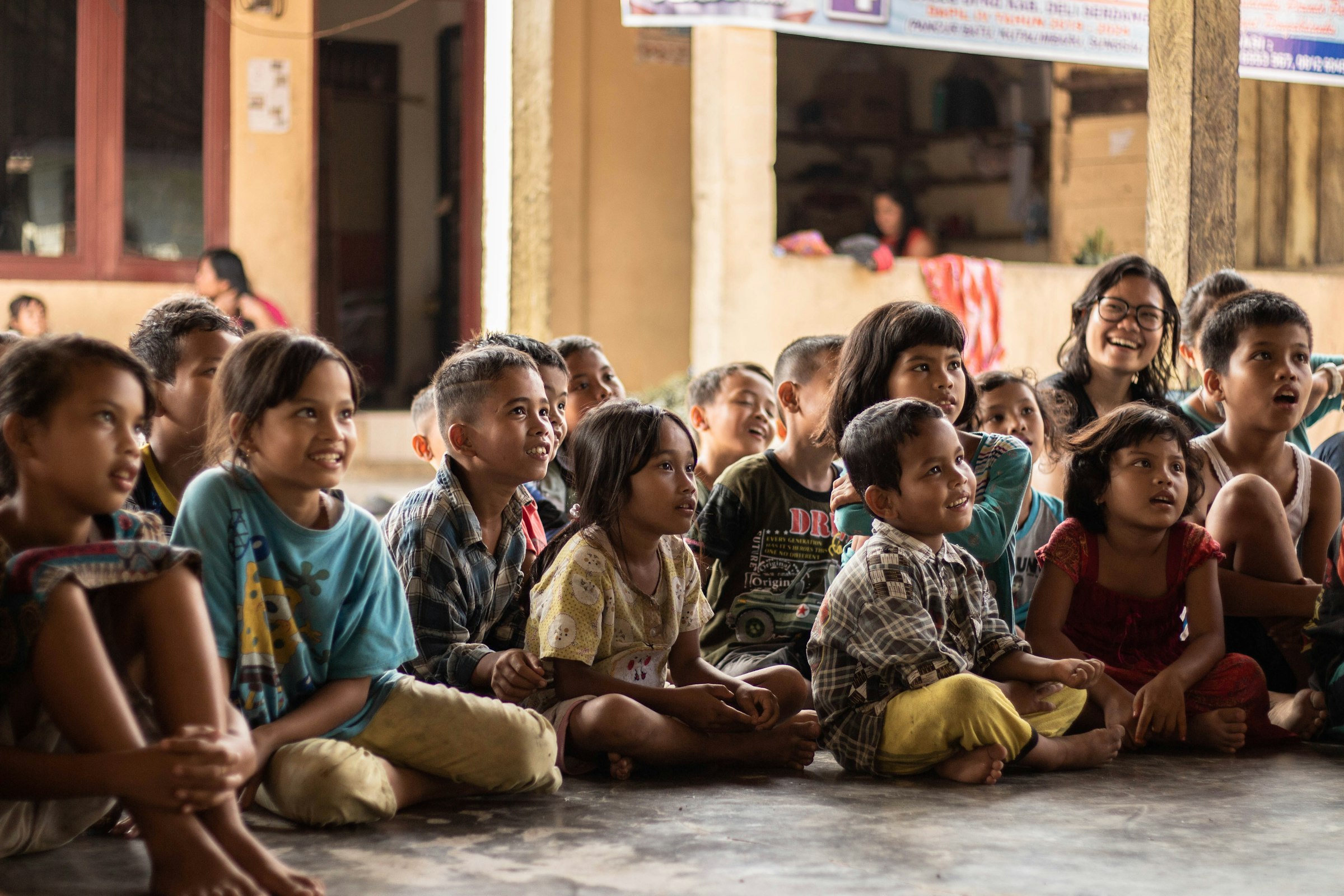 Children gathered together outdoors at a community learning session in Namu Keeling, Indonesia