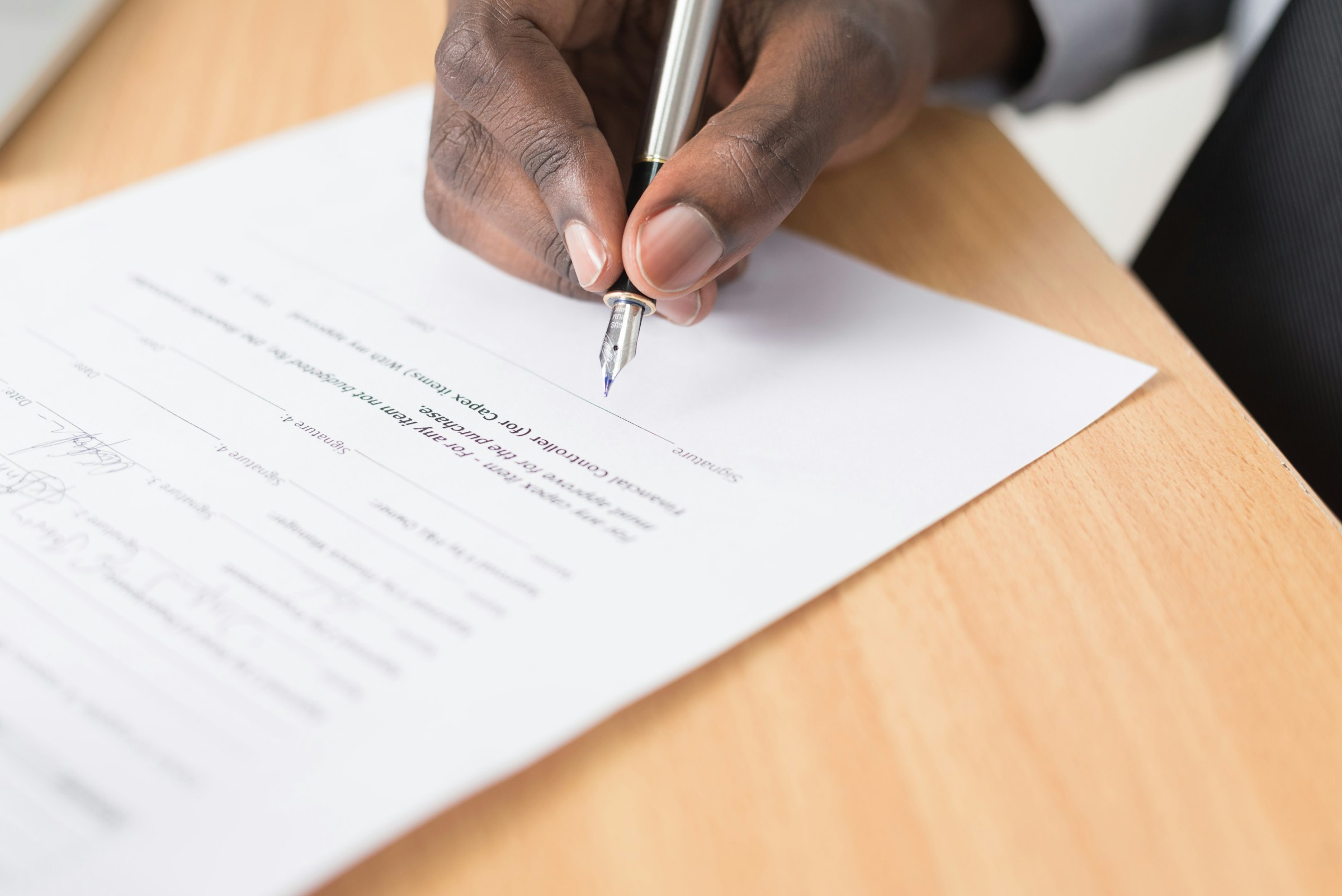 Close-up of a hand signing a document with a fountain pen, Nairobi, Kenya